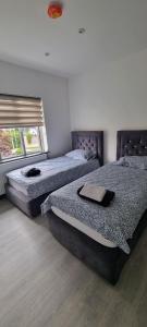 2 camas individuais num quarto com uma janela em Modern 2 BDR apartment em Londres