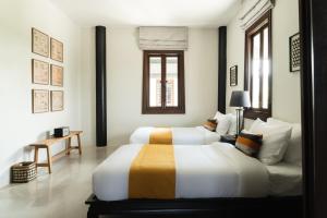 een slaapkamer met 2 bedden en een bank bij Siri Sala Private Thai Villa in Bangkok