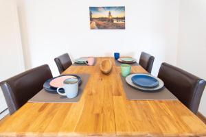 une table en bois avec des assiettes et des tasses dessus dans l'établissement Wohnung Waage, à Sankt-Andreasberg