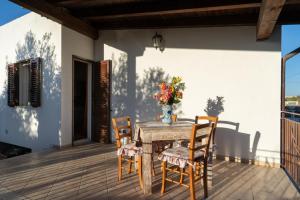 un tavolo con sedie e un vaso di fiori su un patio di Villa Cecilia a Sciacca