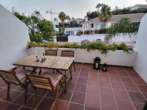 patio con mesa de madera y sillas en el balcón en Cozy apartment next to Hard Rock Hotel, en Marbella