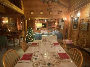 a dining room with a table and a christmas tree at Chalet bois 9 pers, Grand confort, près pistes et commerces, Wi-Fi, Equipé, Parking, Non fumeur - FR-1-733-18 in Crest-Voland