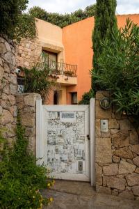 a white door in a stone wall next to a building at Monti Mannu Art in Abbiadori