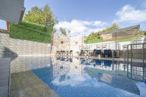 a swimming pool with a table and an umbrella at Antioch Apart Otel in Didim