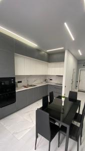 a kitchen with a black table and black chairs at Heaven Apartment Mountain View in Almaty