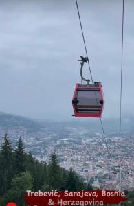 a person riding a ski lift in the sky at Apartment Mesic is 200 m away from the international airport in Sarajevo in Sarajevo