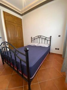 un piccolo letto in una camera con porta in legno di Appartement Sidi Bouzid a El Jadida