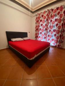 una camera con un letto con copriletto rosso di Appartement Sidi Bouzid a El Jadida