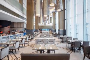 a dining room with tables and chairs and chandeliers at Sheraton Manila Hotel in Manila