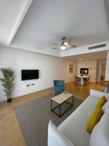 sala de estar con sofá blanco y TV en LUXURY Casares del Mar D BJ2, en Casares