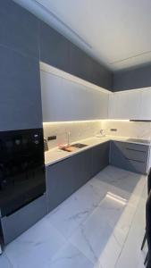 a kitchen with white cabinets and a sink and a stove at Heaven Apartment Mountain View in Almaty
