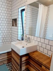 een badkamer met een witte wastafel en een spiegel bij ZENergy - GUEST HOUSE in Odeceixe