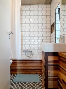 ein Badezimmer mit einer Badewanne und einem Waschbecken in der Unterkunft ZENergy - GUEST HOUSE in Odeceixe