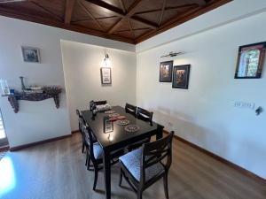a dining room with a black table and chairs at Villa Bliss Lakeside in Nainital