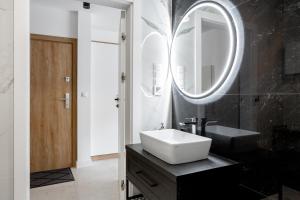 a bathroom with a sink and a mirror at ApartamentyIn Belnihel in Hel