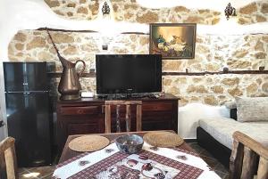 - un salon avec une télévision et une table dans l'établissement Casa Felicha Къща Щастие Хасково, à Haskovo