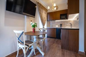 cocina con mesa, 2 sillas y barra en Keramikos metro st luxury studio for 2 by MPS en Athens