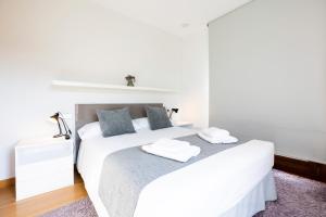 een witte slaapkamer met 2 bedden en een paars tapijt bij Jaizkibel by Basquelidays in Hondarribia
