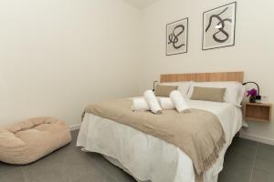 a bedroom with a large bed and a ottoman at Lofts Jumaral - La Magdalena in Córdoba