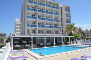 a hotel with a swimming pool in front of a building at Yasmin Hotel in Ayvalık