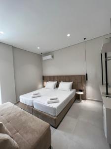 a bedroom with two beds and a television in it at Astoria Rooms in Sarandë +45 photos