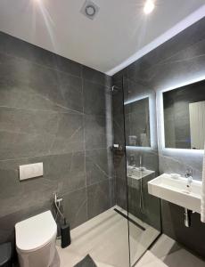 a bathroom with a shower and a toilet and a sink at Astoria Rooms in Sarandë
