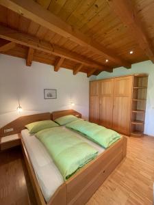 a bedroom with a large bed with green pillows at Feldererhof in Postal