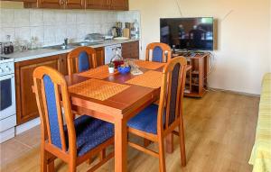 une cuisine avec une table en bois et des chaises bleues dans l'établissement Nice Home In Knin With Kitchen, 