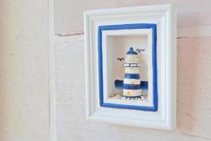 a picture of a lighthouse in a frame on a wall at Rooms Sunce Panorama Residence, Supetar Island Brac Traveler's Choice in Supetar