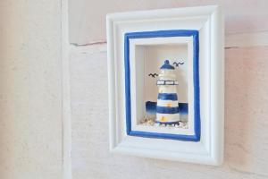 a picture of a lighthouse in a frame on a wall at ꕥ ROOMS SUNCE, Family choice, Best Panoramic view, Supetar Island Brac in Supetar