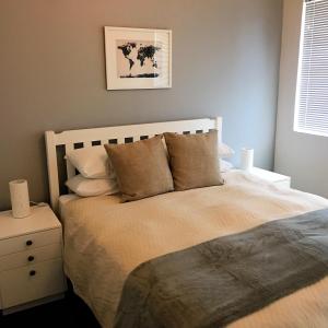 1 dormitorio con 1 cama grande con almohadas en Overbeek 1 Bedroom 702 Apartment on Kloof Street, en Ciudad del Cabo