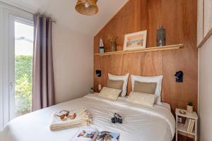 Un dormitorio con una gran cama blanca con zapatos. en Camping La Forêt, en Saint-Jean-de-Monts