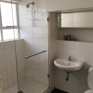 y baño con lavabo y ducha acristalada. en Overbeek 1 Bedroom 702 Apartment on Kloof Street, en Ciudad del Cabo