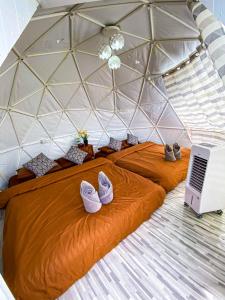 a bed in a geodesic dome with shoes on it at Mon Jam Memory Camp in Mon Jam