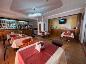 un restaurante con 2 mesas y un bar en Hotel Martini en Nápoles