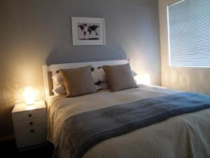 1 dormitorio con 1 cama con 2 lámparas en una mesita de noche en Overbeek 1 Bedroom 702 Apartment on Kloof Street, en Ciudad del Cabo