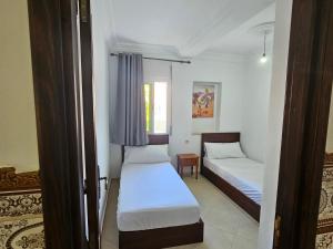 1 Schlafzimmer mit 2 Betten und einem Fenster in der Unterkunft Résidence Anouar in Tétouan