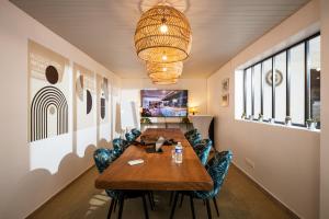 una sala de conferencias con mesa de madera y sillas en Hôtel Les Sables - Urban Style - by Logis Hotels, en Canet-en-Roussillon