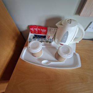 una tetera y tazas en una bandeja sobre una mesa en West View Accomodation en Louisburgh