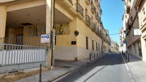 an empty street in an alley between two buildings at Olivae Hostal Boutique in Cáceres