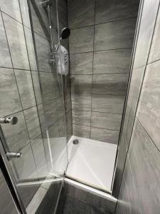 a shower with a glass door in a bathroom at Limpenny Garden Flat in Nottingham