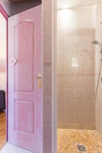 a pink door in a bathroom with a shower at La Glycine et La Villanelle  +31 photos