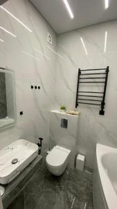 a white bathroom with a toilet and a sink at Heaven Apartment Mountain View in Almaty
