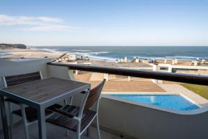een balkon met een tafel en uitzicht op de oceaan bij Pérola do Mar in Foz do Arelho