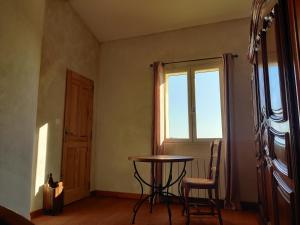 a room with a table and chairs and a window at LE CHARME DU VENTOUX in Crillon-le-Brave