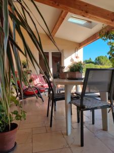 eine Terrasse mit einem Tisch und Stühlen auf einer Terrasse in der Unterkunft LE CHARME DU VENTOUX in Crillon-le-Brave