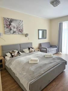 ein Schlafzimmer mit einem großen Bett und einem Sofa in der Unterkunft Lazur Apartamenty in Świnoujście