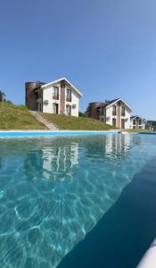 a pool of water with houses in the background at Crown TiM Villa in Vrnjačka Banja