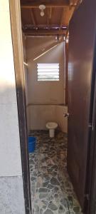 a small bathroom with a toilet and a door at MIRA AgroPark in Kuyambay