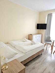 1 Schlafzimmer mit 2 Betten, einem Schreibtisch und einem Stuhl in der Unterkunft Lazur Apartamenty in Świnoujście